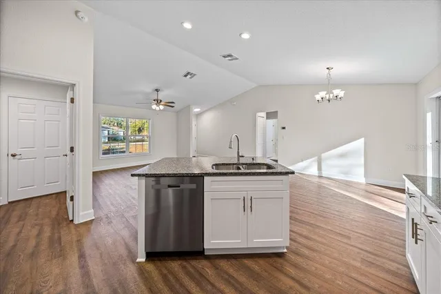 a kitchen with a stove and wooden floor