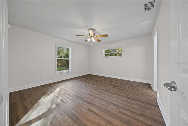wooden floor in an empty room with a window