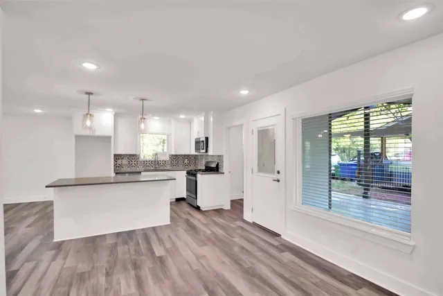 a view of kitchen with wooden floor and electronic appliances