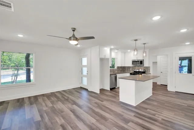 a view of kitchen with stove and white cabinets with wooden floor
