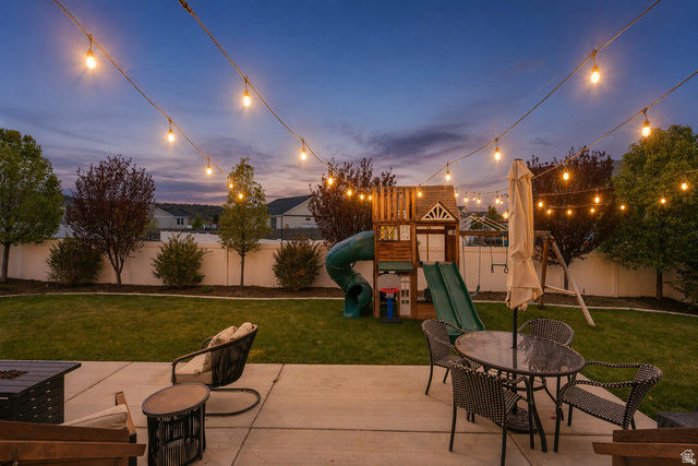 7685 Timber Country Road Eagle Mountain, UT 84005 - Photo 31 of 39 Expansive backyard featuring a concrete patio, string lighting, manicured lawn, and mature trees