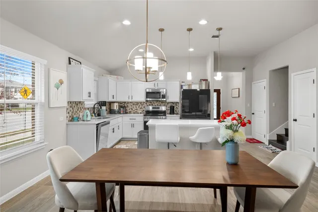 a kitchen with kitchen island a dining table and chairs