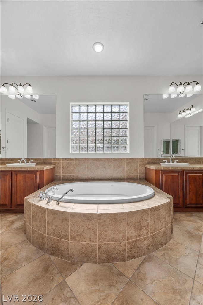2125 De Rouge Avenue Henderson, NV 89044 - Photo 10 of 96 Indulge in a tranquil soak within this well-appointed bathroom featuring a built-in tub and generous vanity space.
