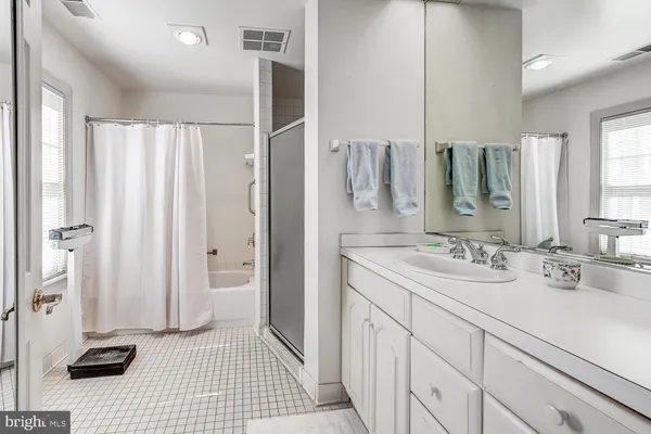 a bathroom with a sink a toilet and a large mirror