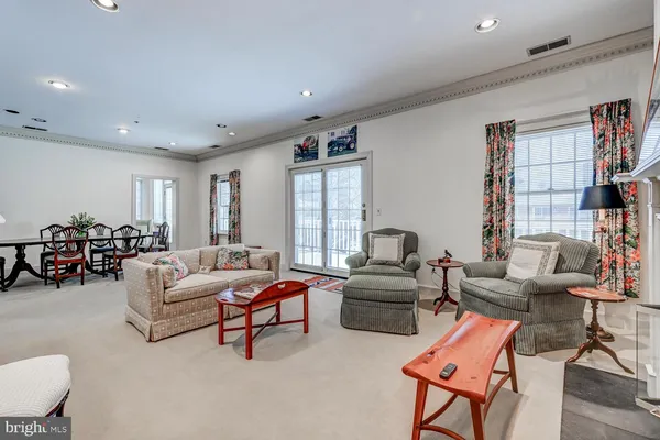 a living room with furniture a bookshelf and a window
