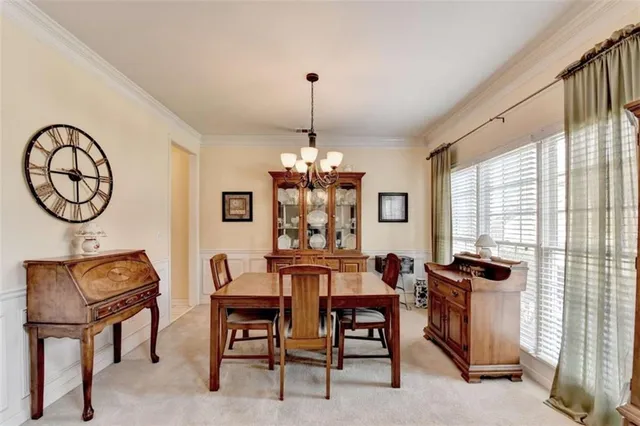 a dining room with wooden floor a chandelier a wooden table and chairs