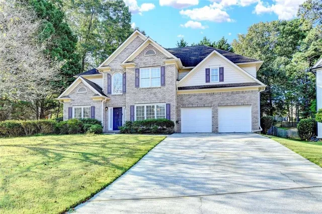 a front view of a house with a yard and garage