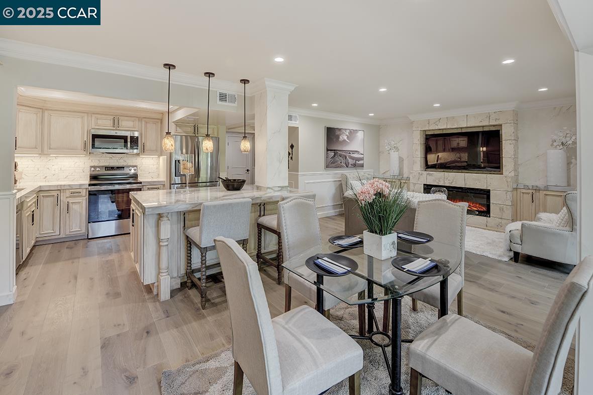 a view of kitchen with stainless steel appliances refrigerator stove dining table and chairs