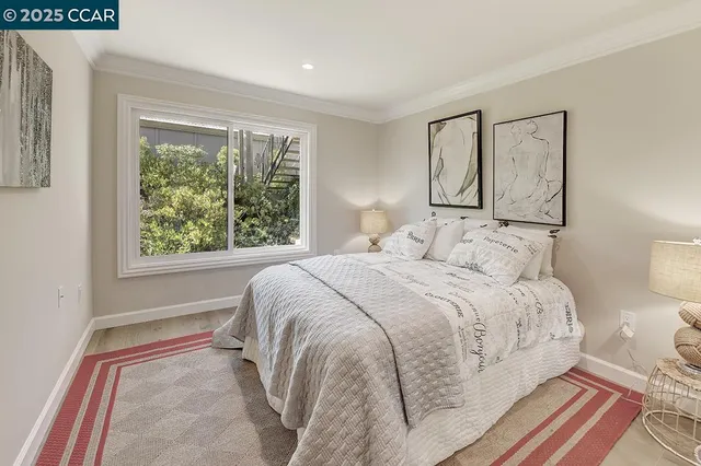 a bedroom with a bed and a painting on the wall