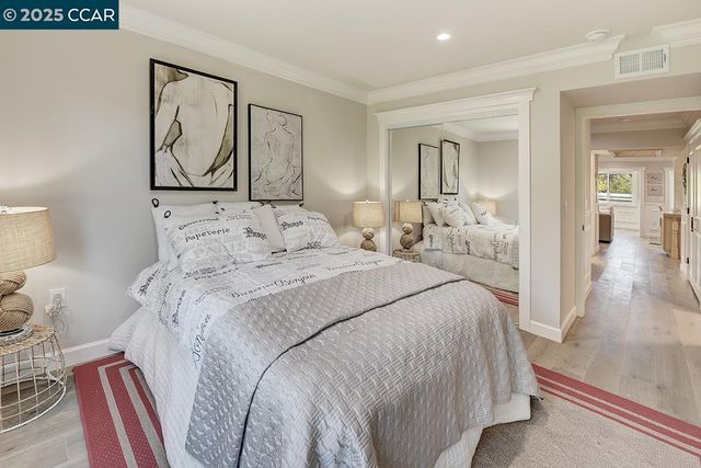 a bedroom with a large bed and a painting on the wall