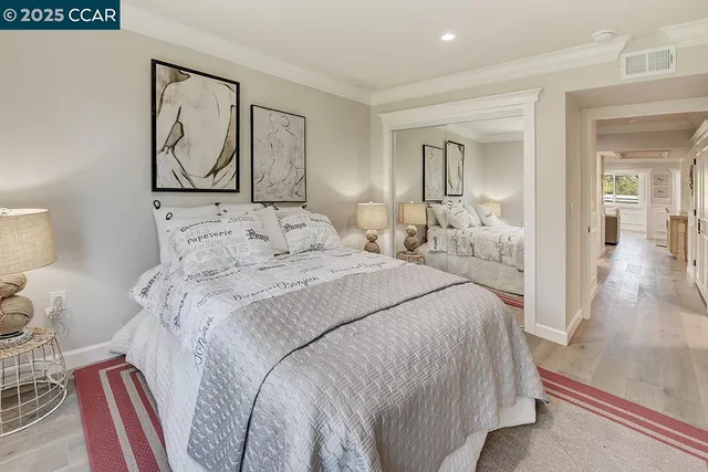 a bedroom with a large bed and a painting on the wall