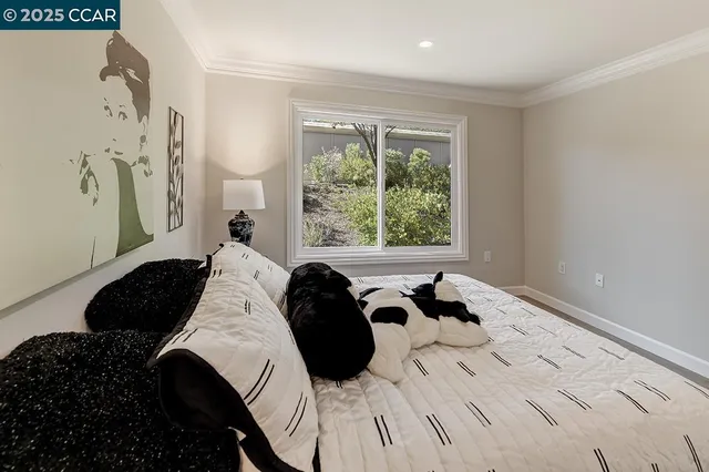 a bedroom with a bed and a large window