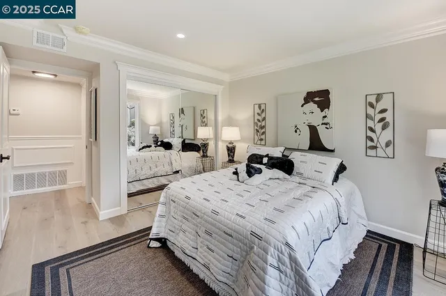 a bedroom with a bed and a large mirror