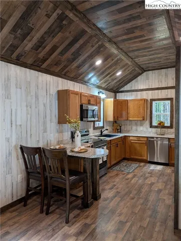 a kitchen with a table chairs sink and wooden floor