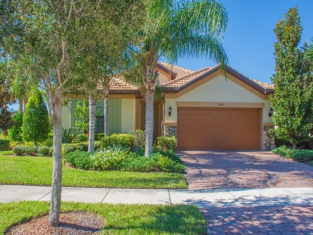 a front view of a house with a yard and potted plants