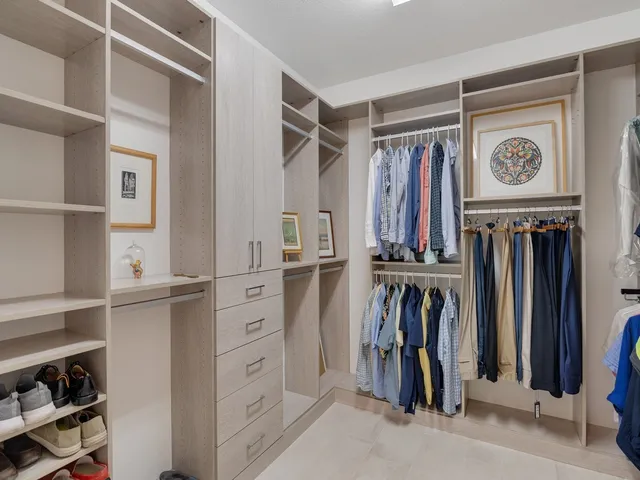 a view of walk in closet with clothes and shoes