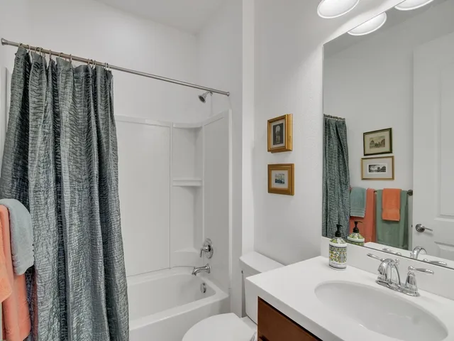 a bathroom with a granite countertop sink a mirror a shower and a bathtub