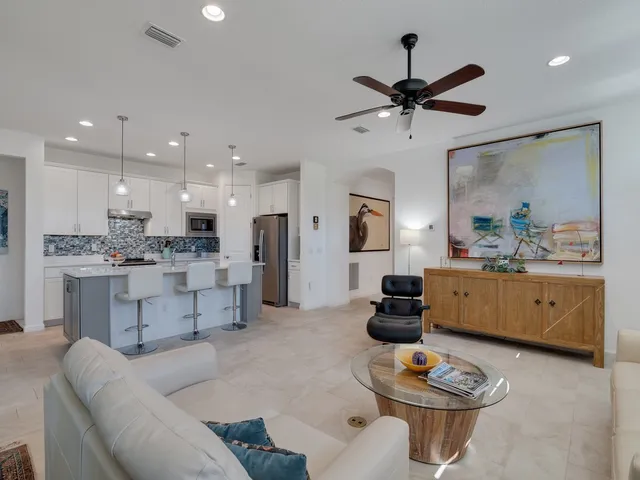 a kitchen with stainless steel appliances kitchen island granite countertop a stove a sink a dining table and chairs with wooden floor