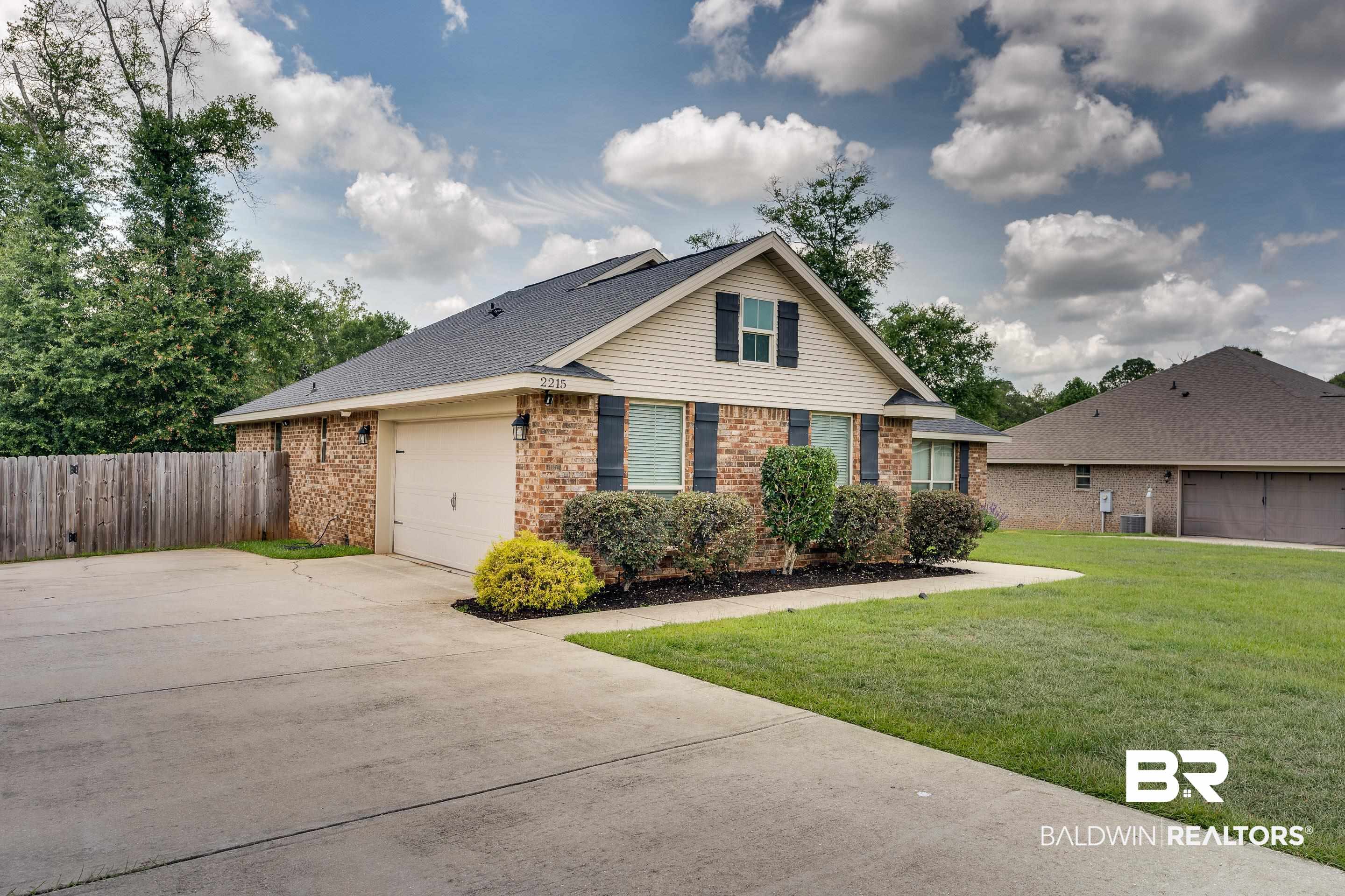 2215 Fernwood Loop West Semmes, AL 36575 - Photo 2 of 40 Brick and siding exterior featuring a single-car garage, dark shutters, and a gabled roof
