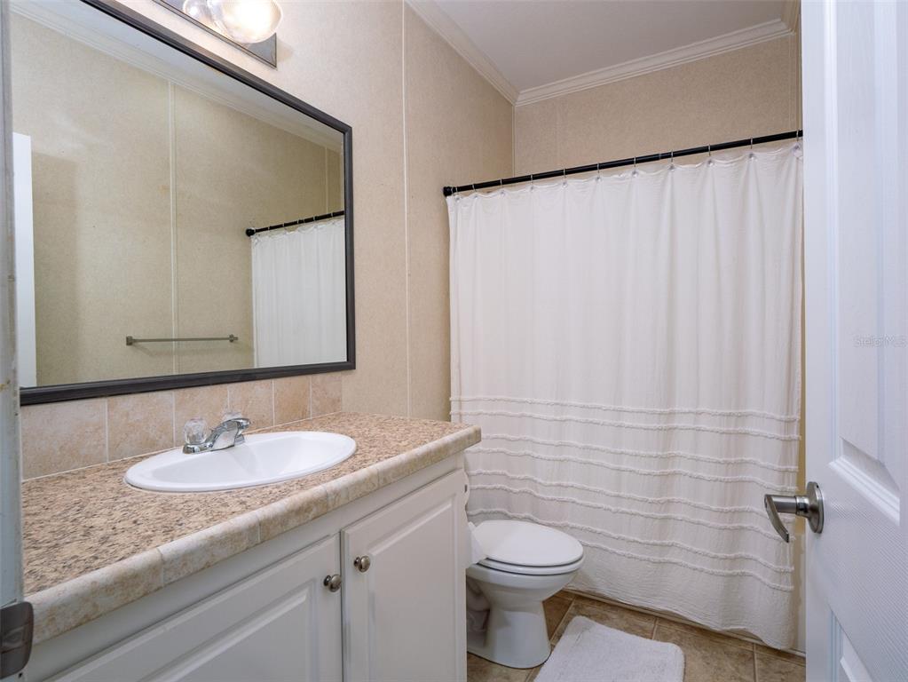 2900 Northwest 68th Avenue Ocala, FL 34482 - Photo 13 of 27 a bathroom with a granite countertop sink a toilet and a mirror