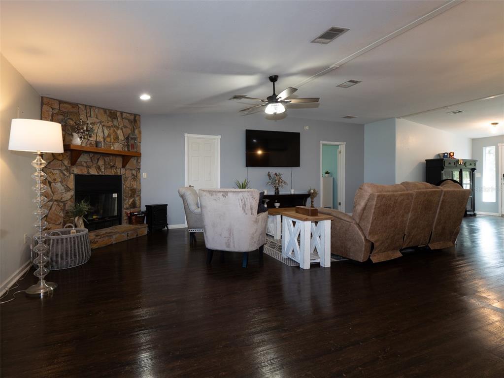 2900 Northwest 68th Avenue Ocala, FL 34482 - Photo 4 of 27 a living room with furniture a fireplace and a flat screen tv