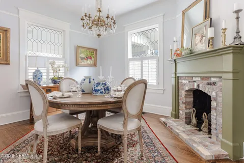 a view of a dining room with furniture a chandelier and wooden floor