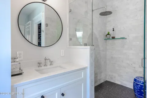 a bathroom with a sink a mirror and a shower