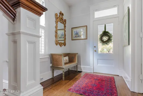 a view of a dining room with furniture a chandelier and wooden floor