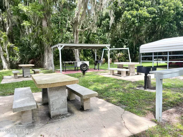 a view of a patio with a table chairs and a small yard