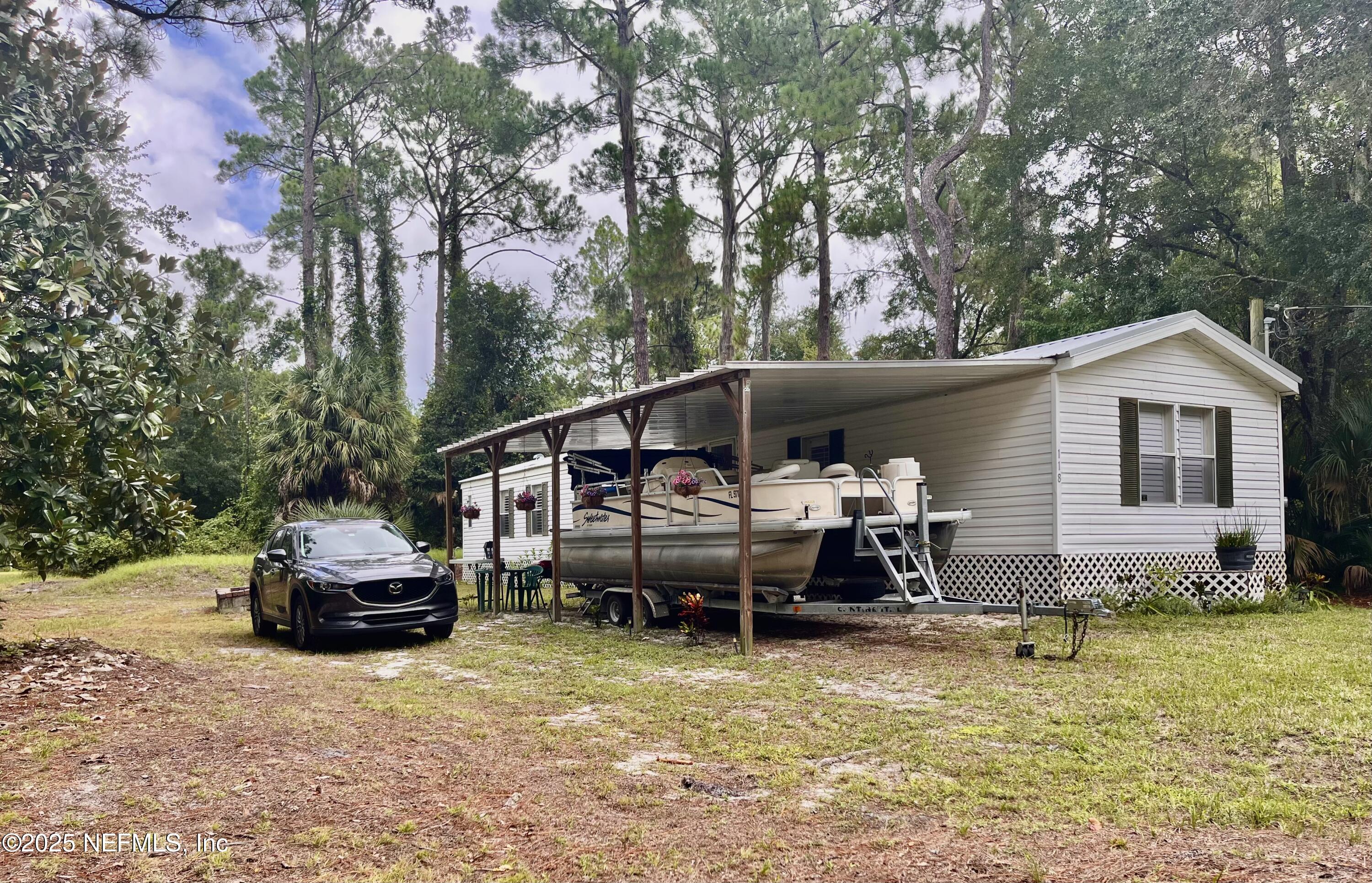118 July Avenue Georgetown, FL 32139 - Photo 2 of 21 a front view of a house with a garden and sitting area