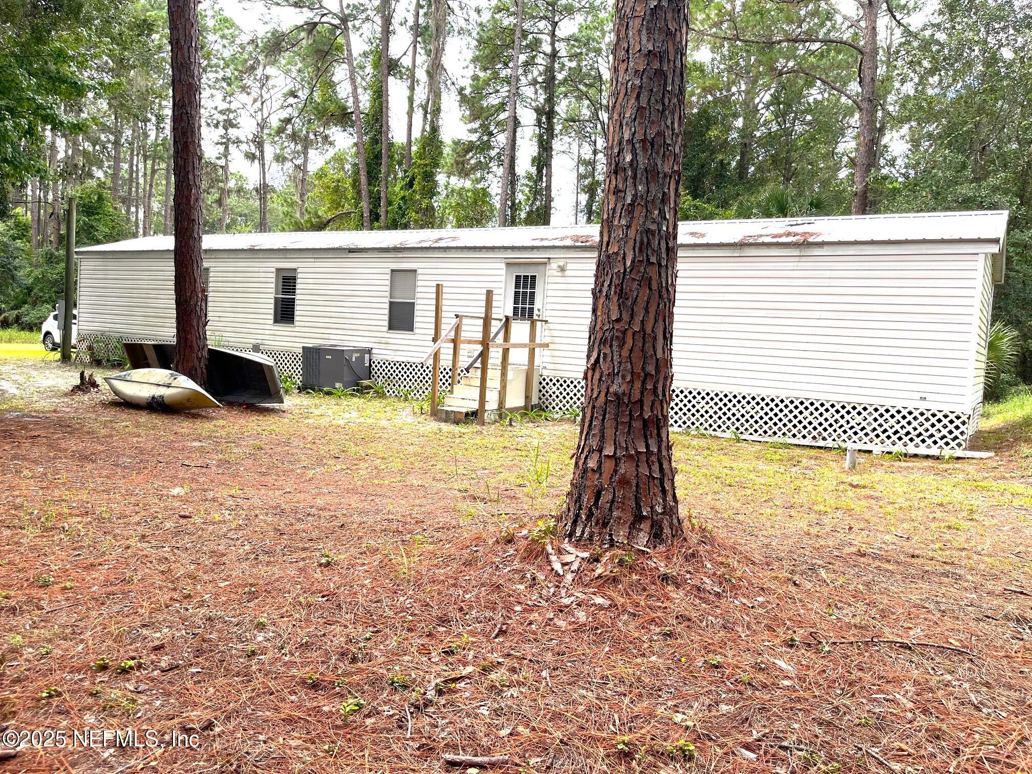 118 July Avenue Georgetown, FL 32139 - Photo 3 of 21 a view of backyard with large trees and wooden fence