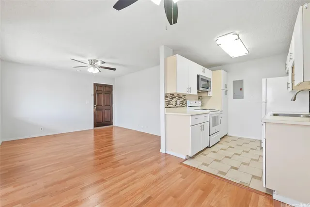 a kitchen with granite countertop a refrigerator and a stove top oven