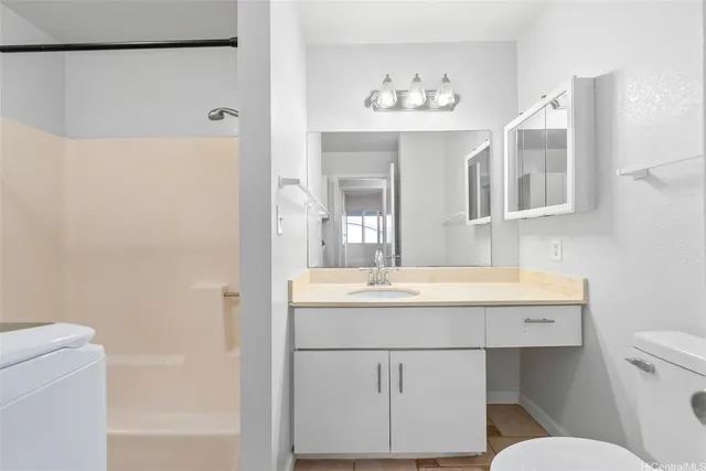 a bathroom with a sink a toilet a mirror and shower