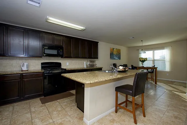 a kitchen with a stove a sink a microwave and a refrigerator