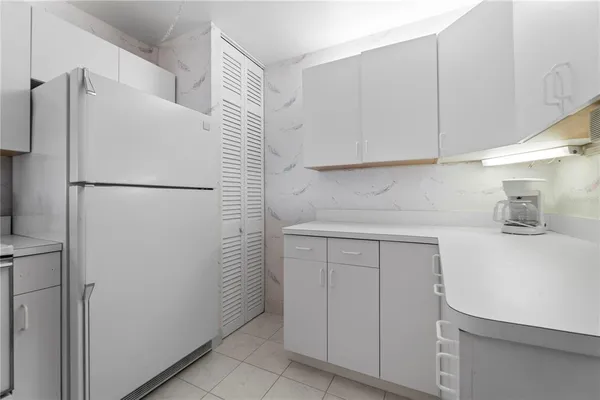 a white refrigerator freezer sitting inside of a kitchen