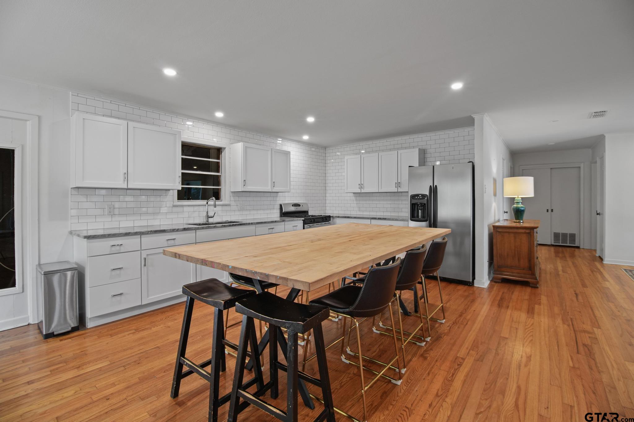 18392 Eastside Road Troup, TX 75789 - Photo 5 of 19 a kitchen with stainless steel appliances granite countertop a kitchen island hardwood floor sink stove dining table and chairs