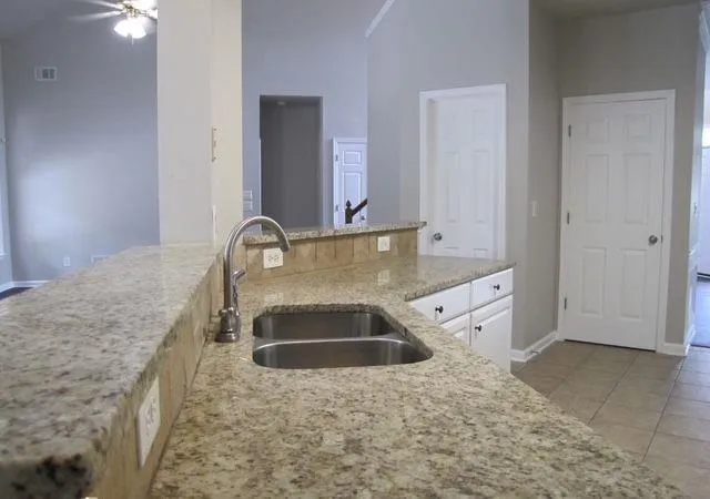 a bathroom with a granite countertop sink and mirror