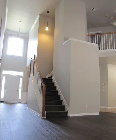 a view of a hallway with entryway wooden floor and stairs