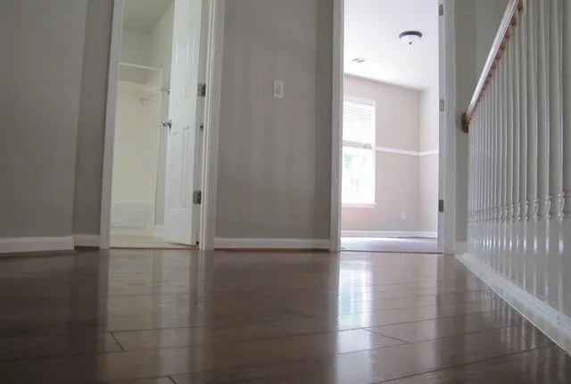 a view of empty room with wooden floor