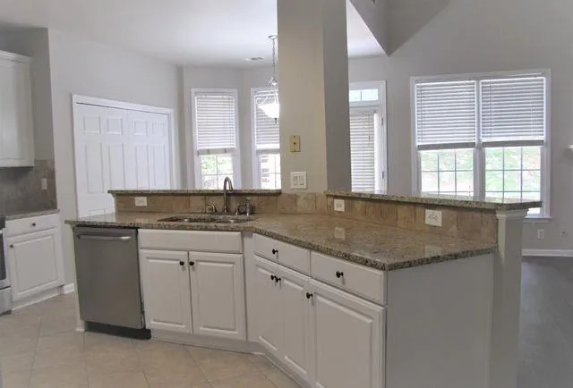 a kitchen with granite countertop white cabinets and a sink