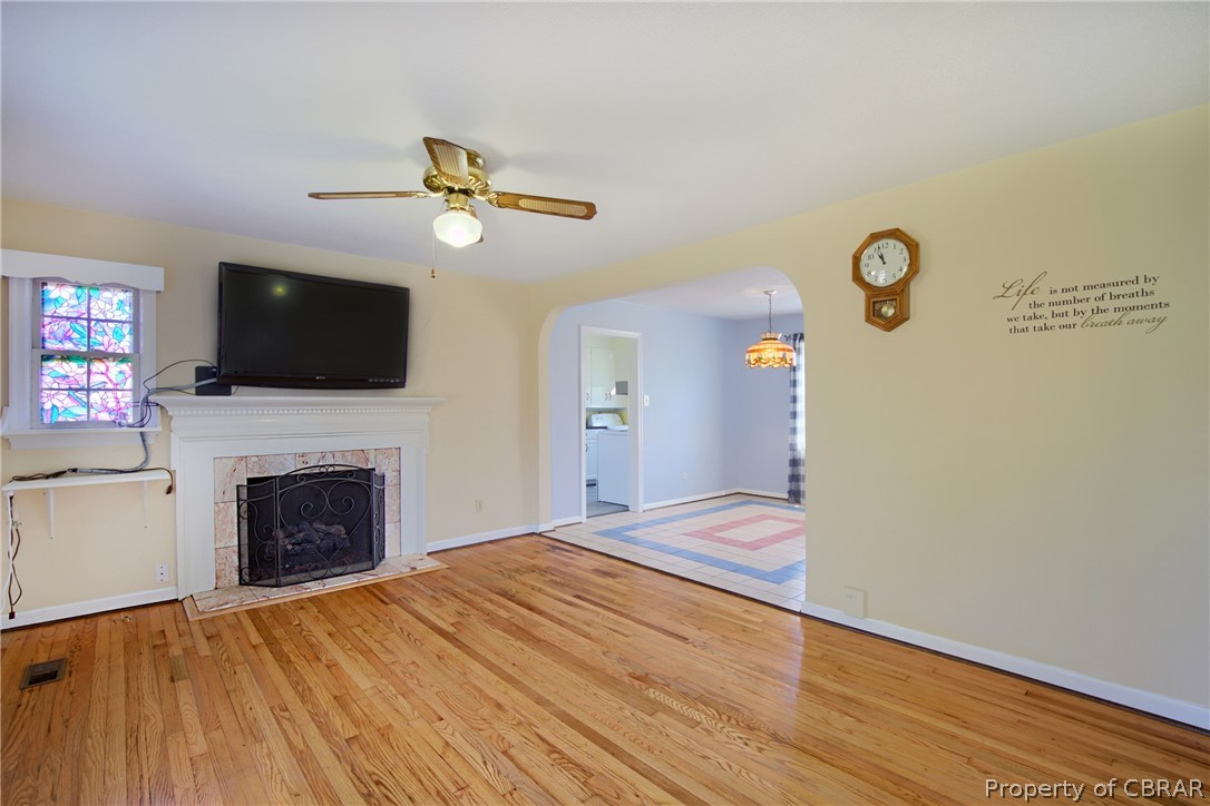 12 Old Meribeth Road Hampton, VA 23669 - Photo 10 of 32 Unfurnished living room with washer / clothes dryer, a tile fireplace, light hardwood / wood-style floors, and ceiling fan