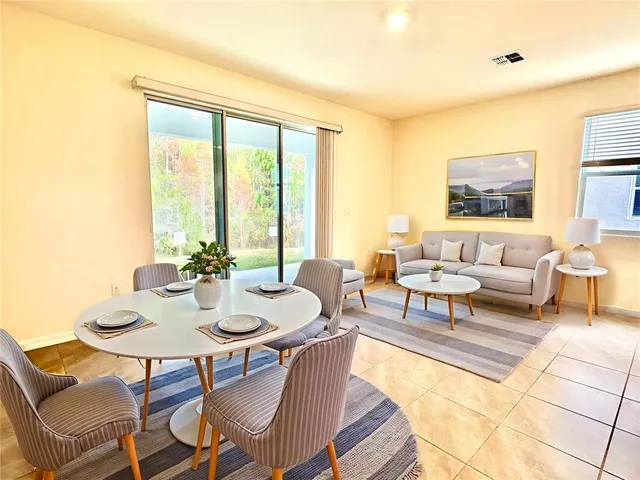 a living room with furniture and floor to ceiling windows