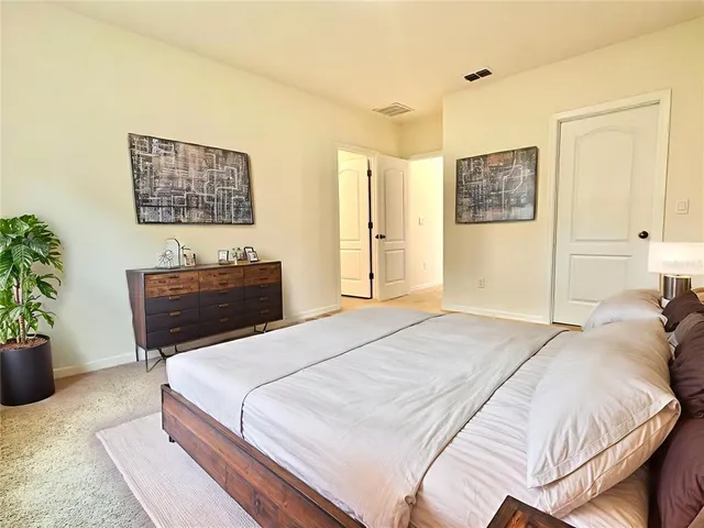 a bedroom with a bed and a potted plant