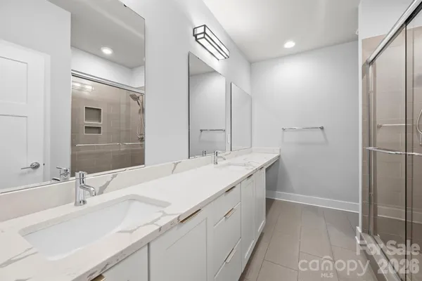 a bathroom with a double vanity sink mirror and shower