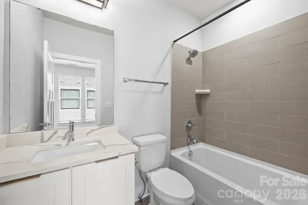 a bathroom with a granite countertop sink a toilet and bathtub