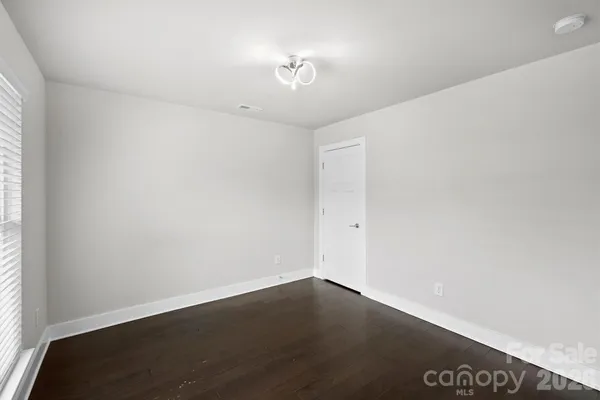 a view of a room with wooden floor and a window
