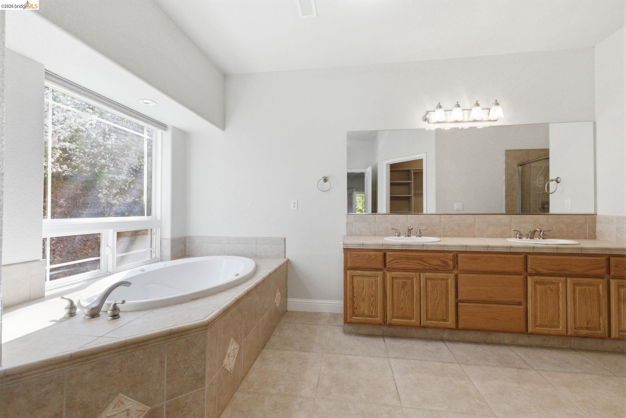 20245 Tuolumne Road North Tuolumne, CA 95379 - Photo 22 of 43 a spacious bathroom with a double vanity sink large mirror and a bathtub