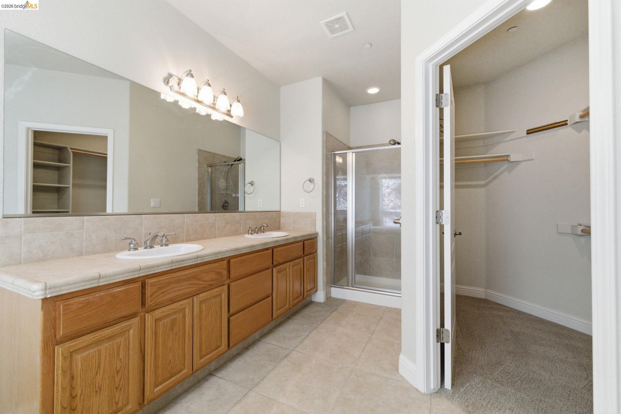 20245 Tuolumne Road North Tuolumne, CA 95379 - Photo 24 of 43 a bathroom with a double vanity sink a mirror and a shower