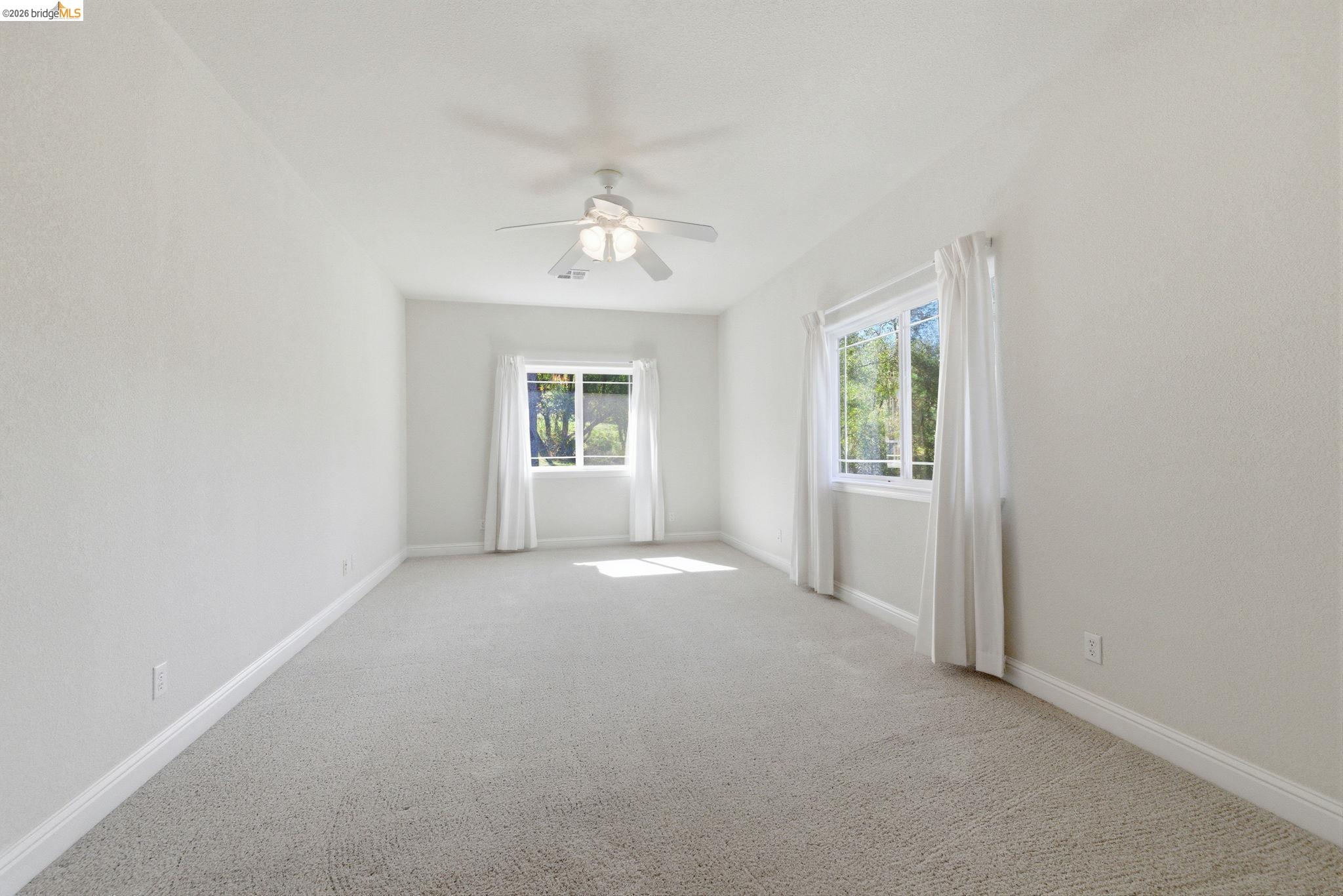 20245 Tuolumne Road North Tuolumne, CA 95379 - Photo 34 of 43 an empty room with windows and chandelier fan