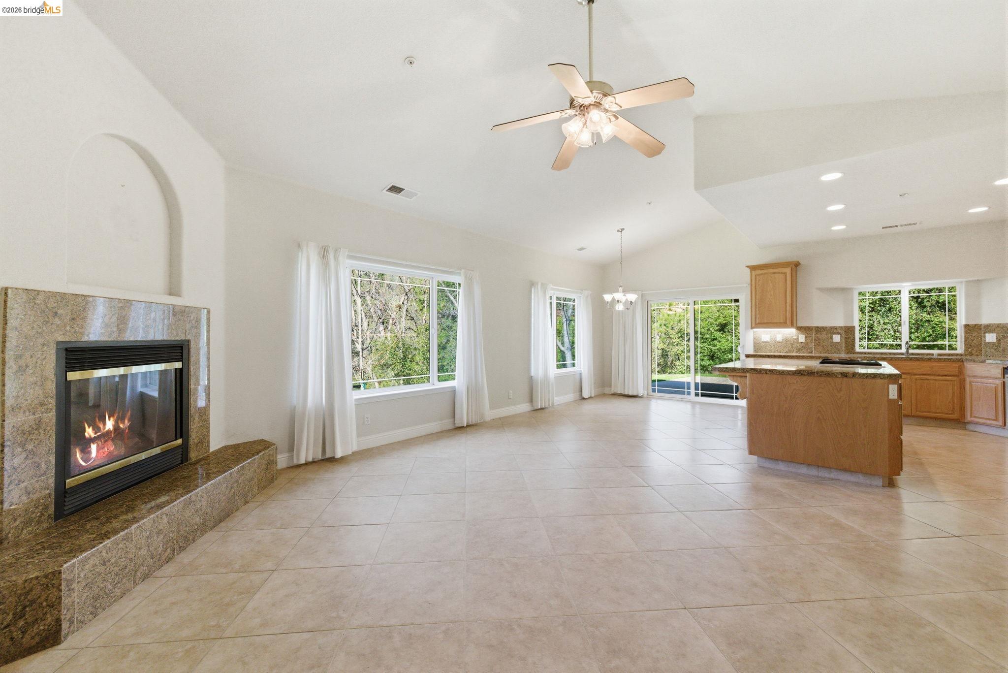 20245 Tuolumne Road North Tuolumne, CA 95379 - Photo 6 of 43 a view of a livingroom with a fireplace a ceiling fan and windows